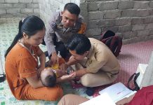 Bhabinkamtibmas Polsek Bambalamotu Dampingi Petugas dan Kader Posyandu Door to door Lakukan Posyandu Keliling