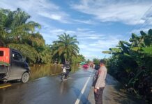 Banjir Genangi Jalan, Personel Polsek Pasangkayu Lakukan Gatur Hingga Bantu Pengguna Jalan