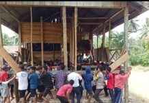 Wujud Kebersamaan, Bhabinkamtibmas Polsek Bambalamotu Gotong Royong Bersama Warga Angkat Rumah