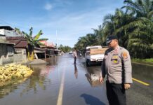 Kapolsek Pasangkayu Pantau Luapan Air Yang Sudah Sampai Ke Bahu Jalan Trans Sulawesi