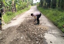 Bhabinkamtibmas Polres Pasangkayu Gotong Royong Bersama Warga bersihkan Material Di Jalan