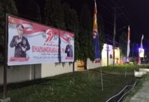 Humas Polres Pasangkayu Pasang Spanduk Hari Bhayangkara ke-79 Di Depan Mako Dan Di Titik Strategis