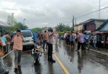 Tak Perduli Cuaca Hujan, Bhabinkamtibmas Polsek Bambalamotu Tetap Mengawal Jenazah Warga Binaannya