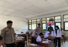 Bhabinkamtibmas Polsek Bambalamotu Kawal Penyaluran Makanan Bergizi di Sekolah, Pastikan Aman dan Tepat SasaSam