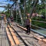 Bhabinkamtibmas Bergerak! Gotong Royong Memperbaiki Jembatan Demi Keselamatan Warga