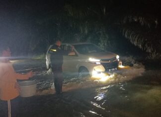 Sigap di Tengah Malam, Bhabinkamtibmas Polsek Pasangkayu Atur Lalu Lintas dan Pantau Luapan Air di Poros Trans Sulawesi